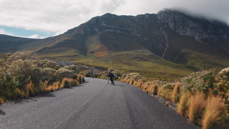 Jóvenes-Amigos-Haciendo-Longboard-Juntos-Cabalgando-Rápido-En-Una-Hermosa-Carretera-Rural-Disfrutando-De-Deportes-Extremos-Navegando-Cuesta-Abajo-Haciendo-Trucos-En-Cámara-Lenta