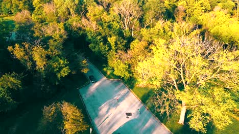 Arial-drone-view-with-people-having-fan-activity-in-the-park-at-sunset-on-summer-day