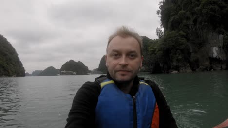 closeup of a man enjoying the scenery of halong bay in vietnam