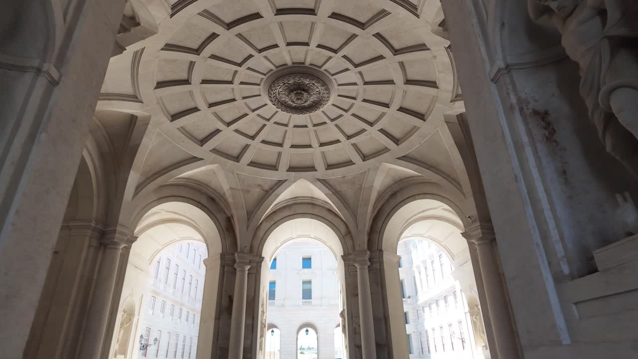Grand interior architecture of the Ajuda Palace featuring intricate arches and sculptures