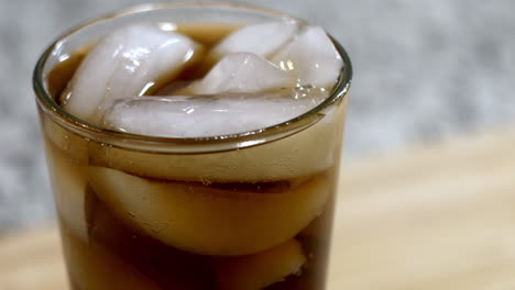 Soda-pop-bubbles-rising-in-glass-set-on-countertop-close-up