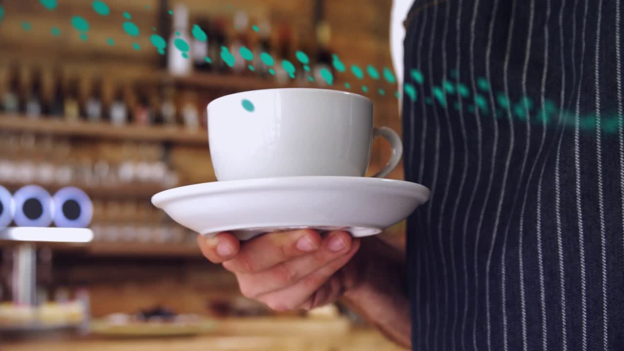 Server reaching forward, steadying and centering cup and saucer in coffee shop, teal dots sweeping