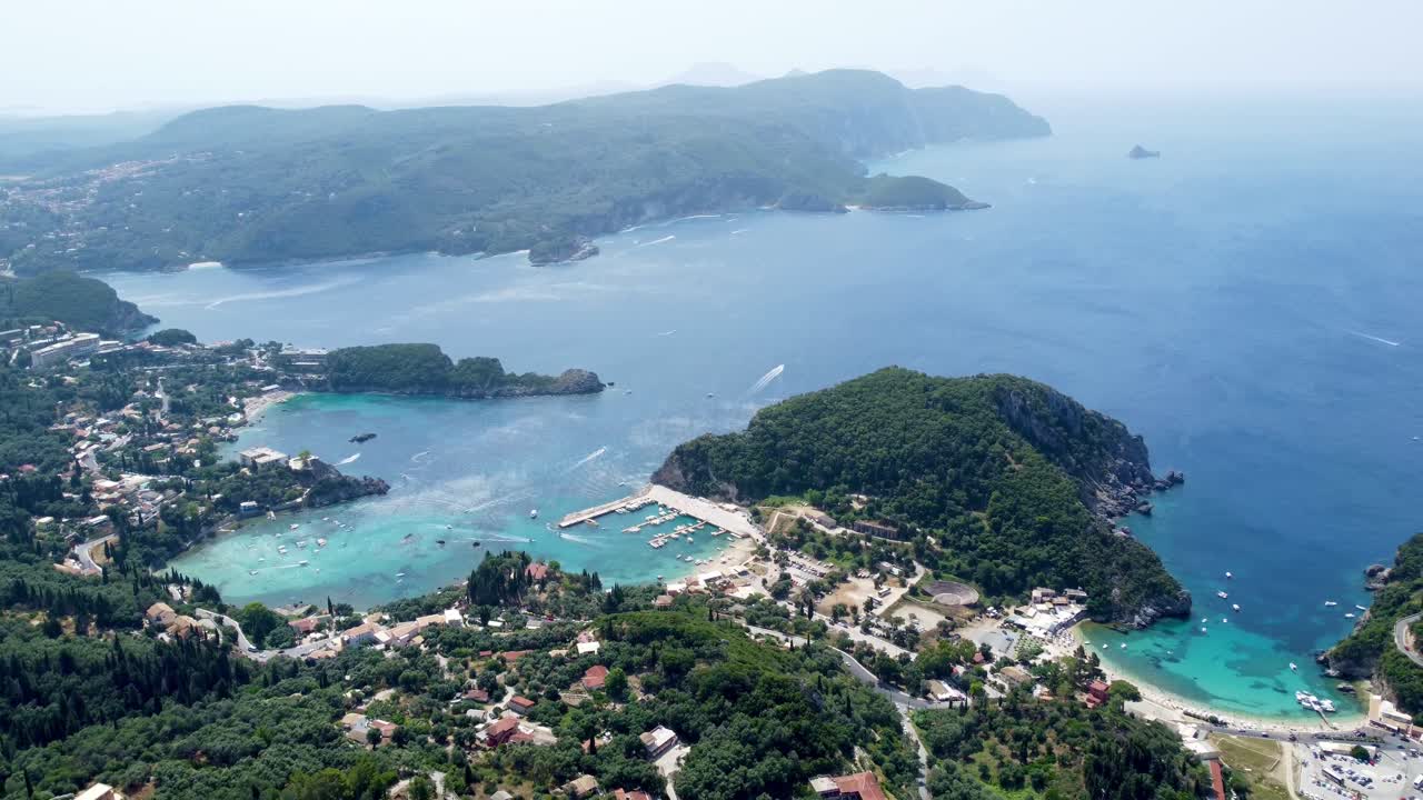 vuelo panorámico de avión no tripulado hacia atrás con vistas a la isla de corfú, grecia, con sus aguas turquesas y ciudades costeras