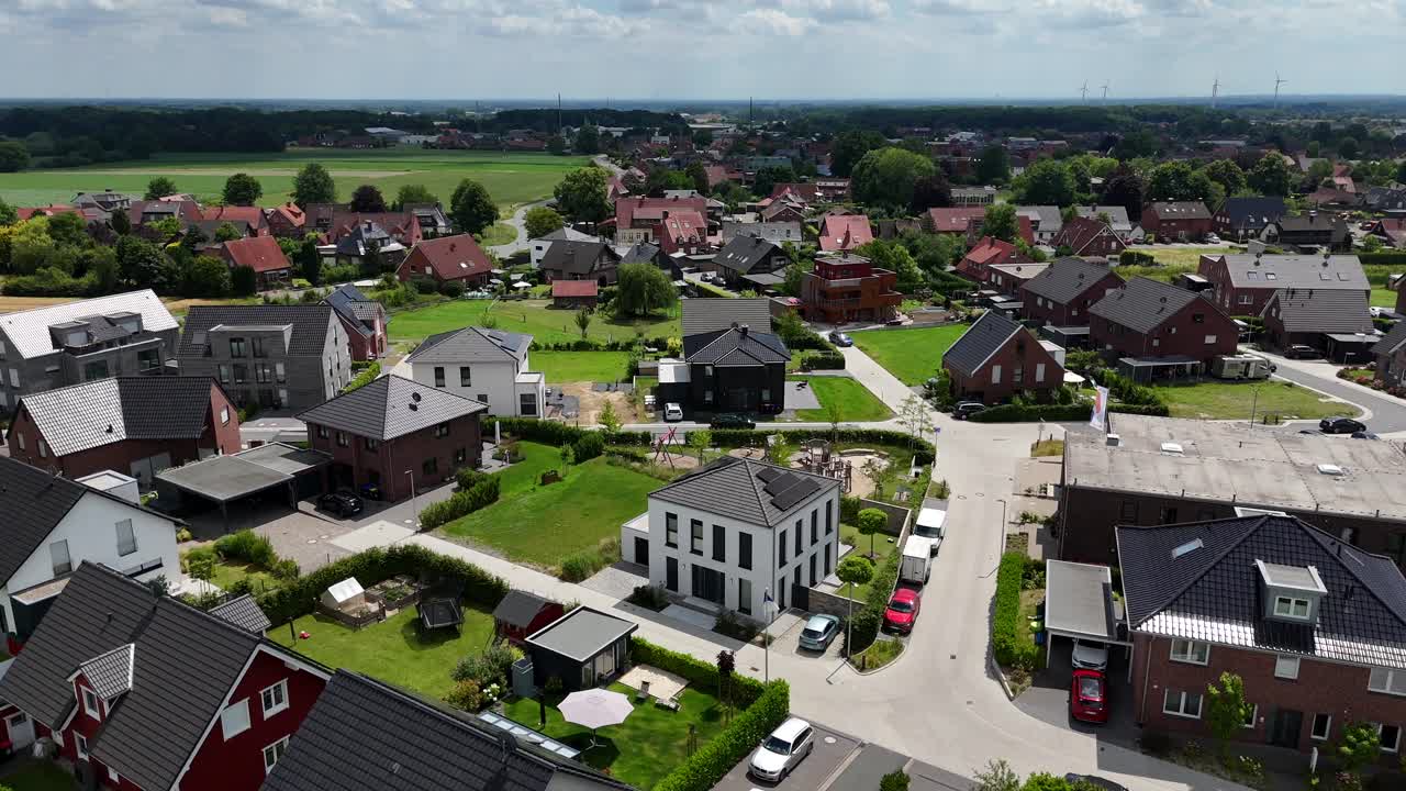 Luxury villas and single family homes during sunny day in America. Aerial orbit shot. Wide shot. Farm fields in distance. Two-story urban houses in new developed area of american town.
