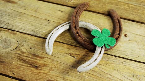 horse shoes and shamrock side view on wooden table for st patricks