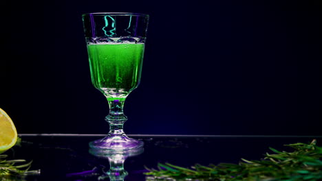 vibrant green absinthe cocktail with lemon and rosemary