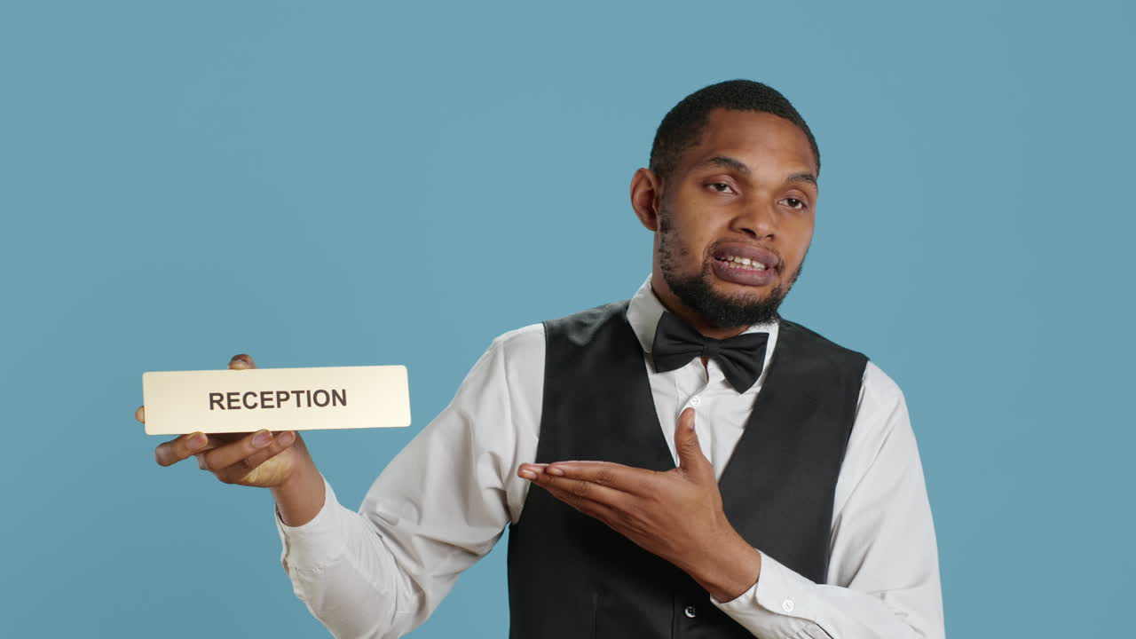 el personal de la conserjería del hotel mostrando el indicador de recepción en la recepción