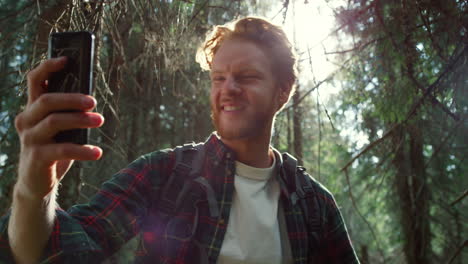 Turista-Tomando-Selfie-En-Teléfono-Móvil-En-El-Bosque.-Chico-Sonriendo-Al-Teléfono-Inteligente