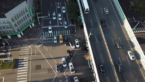 Busy-Avenue-Crossroad-Traffic-in-Taipei-Downtown-on-Golden-Hour-Sunlight,-Birds-Eye-Top-Down-Aerial-View