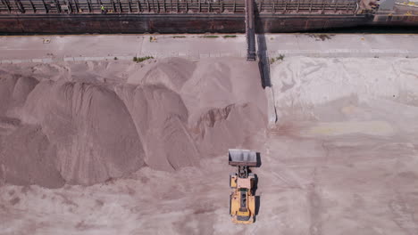 Loader-Machine-Lift-Bucket-To-Catch-Gravel-Falling-From-Conveyor-Belt-On-Barge-At-Gravel-Pit-In-Kingsville-In-Ontario,-Canada