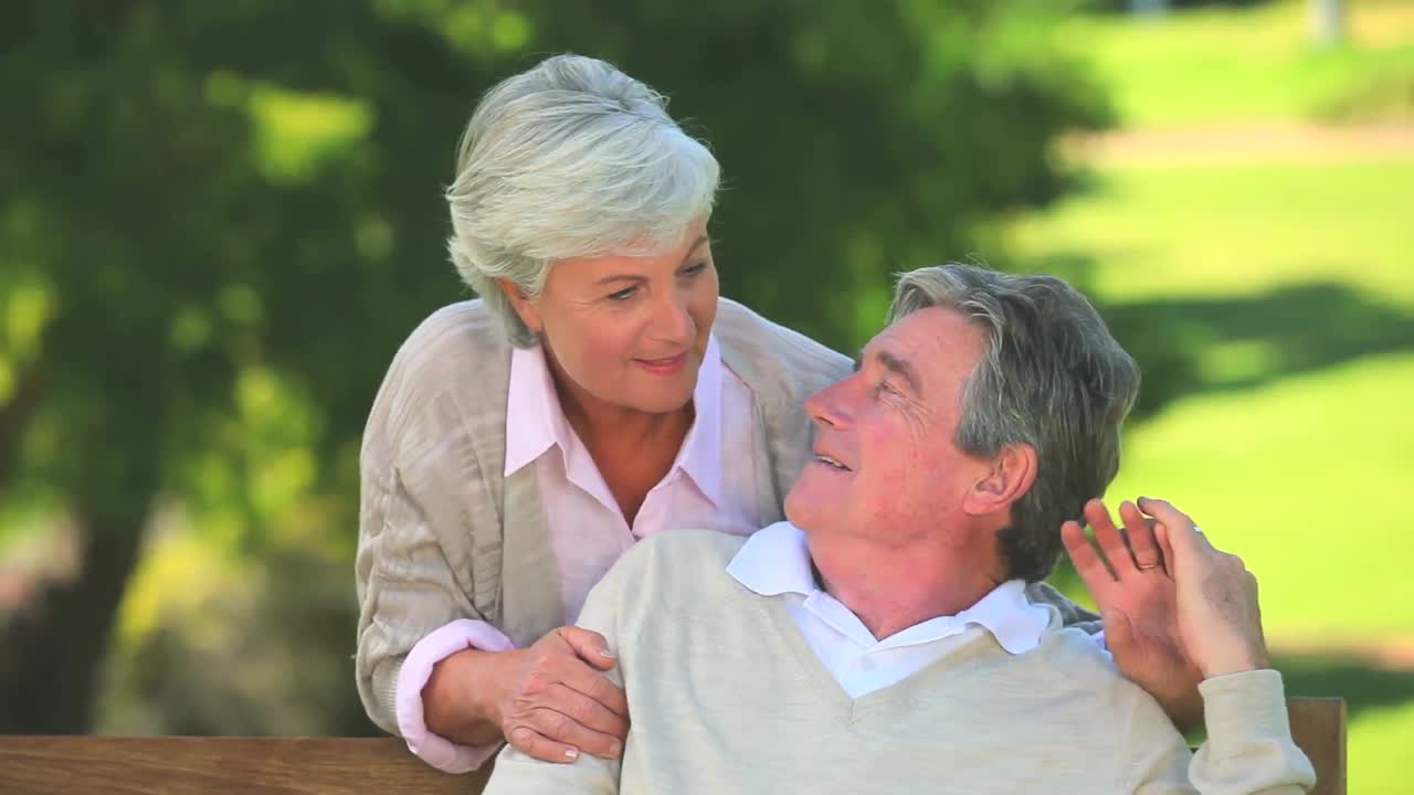 Elderly couple talking while sitting on a bench