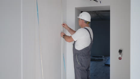 a male electrician installs an led strip to illuminate the walls in the smart home system. installation check lighting