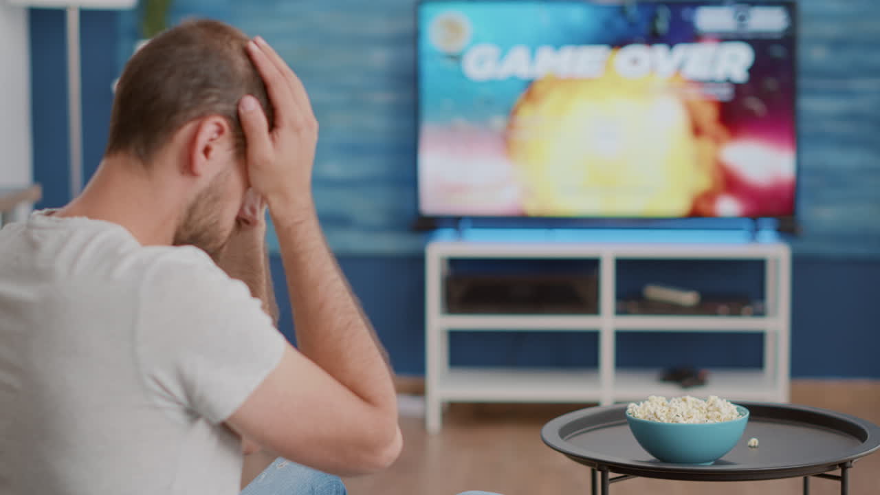Closeup of man holding controller disappointed because losing online first person shooter game