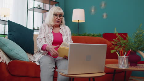 Grandmother-freelance-make-video-call-tutoring-talking-teaching-looking-at-laptop-at-home-office