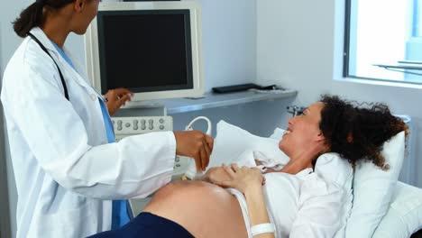 doctor doing ultrasound scan on pregnant woman