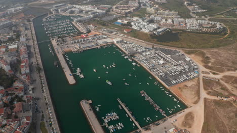 Aerial-drone-view-of-Avenida-dos-Descobrimentos-Promenade-street-with-boats-in-marina-port,-Lagos,-Algarve,-Portugal,-forward-birds-eye-overhead-top-down-view,-day