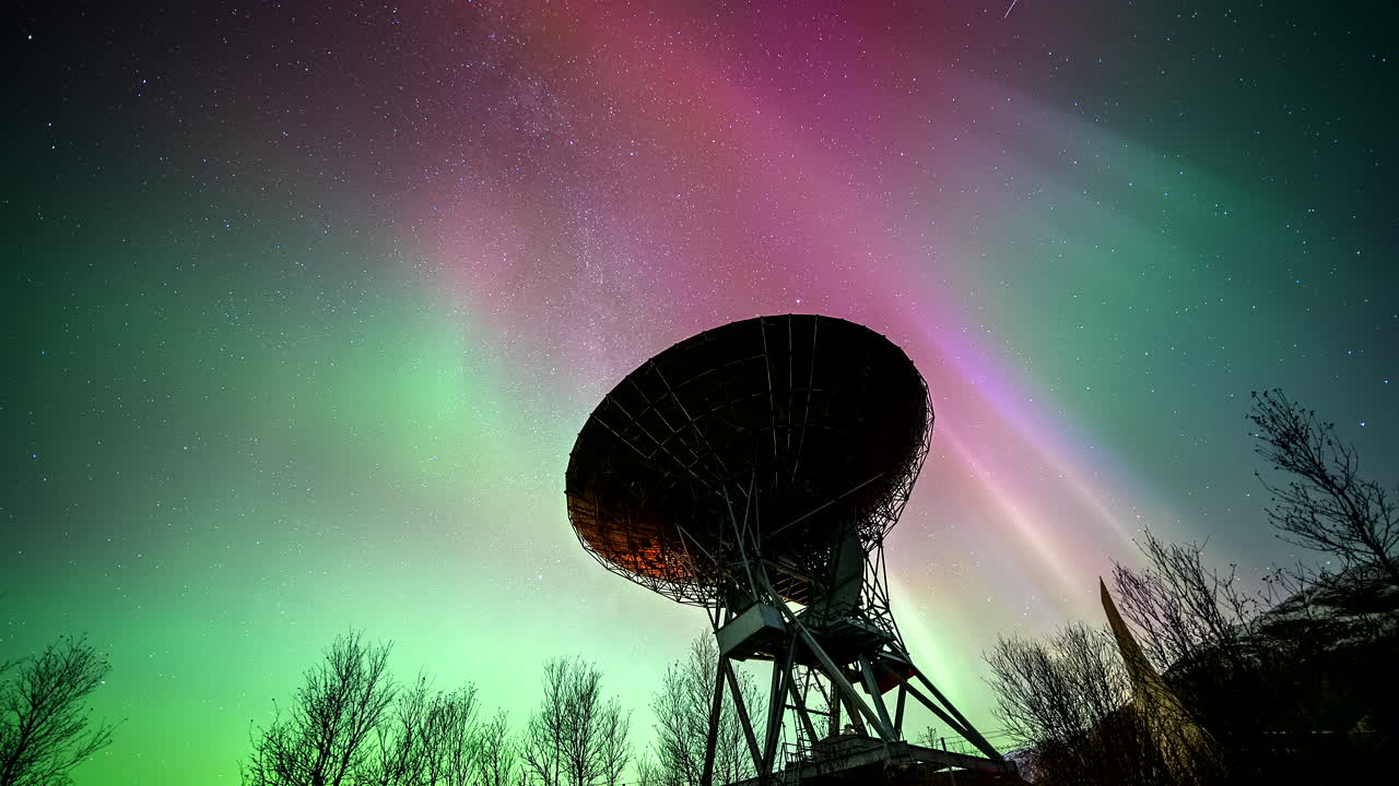 Nordlys på himlen med stjerner over parabolisk forskningsantenne, timelapse.