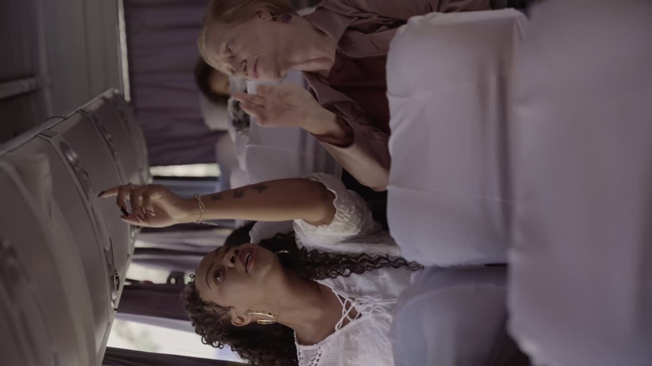 Dos mujeres interactúan dentro de un autobús o avión