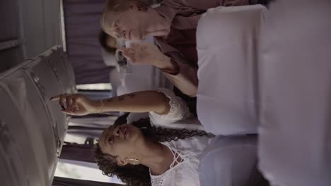 two women interact inside a bus or plane