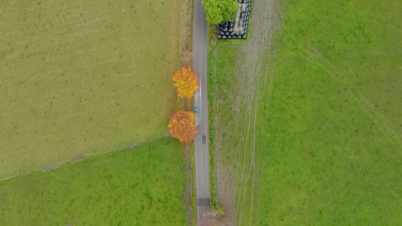 Cyclist aerial top down shot on country road, high aerial bike ride overhead shot, cycling in countryside