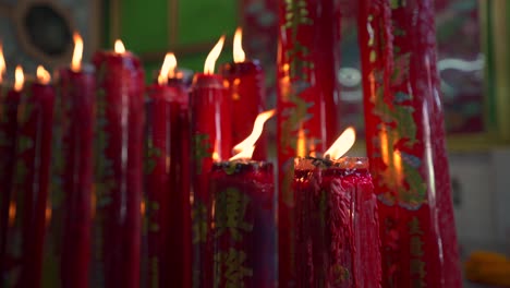 burning candles in a chinese buddhist temple, creating a warm glow in a sacred spiritual setting, detailed closeup