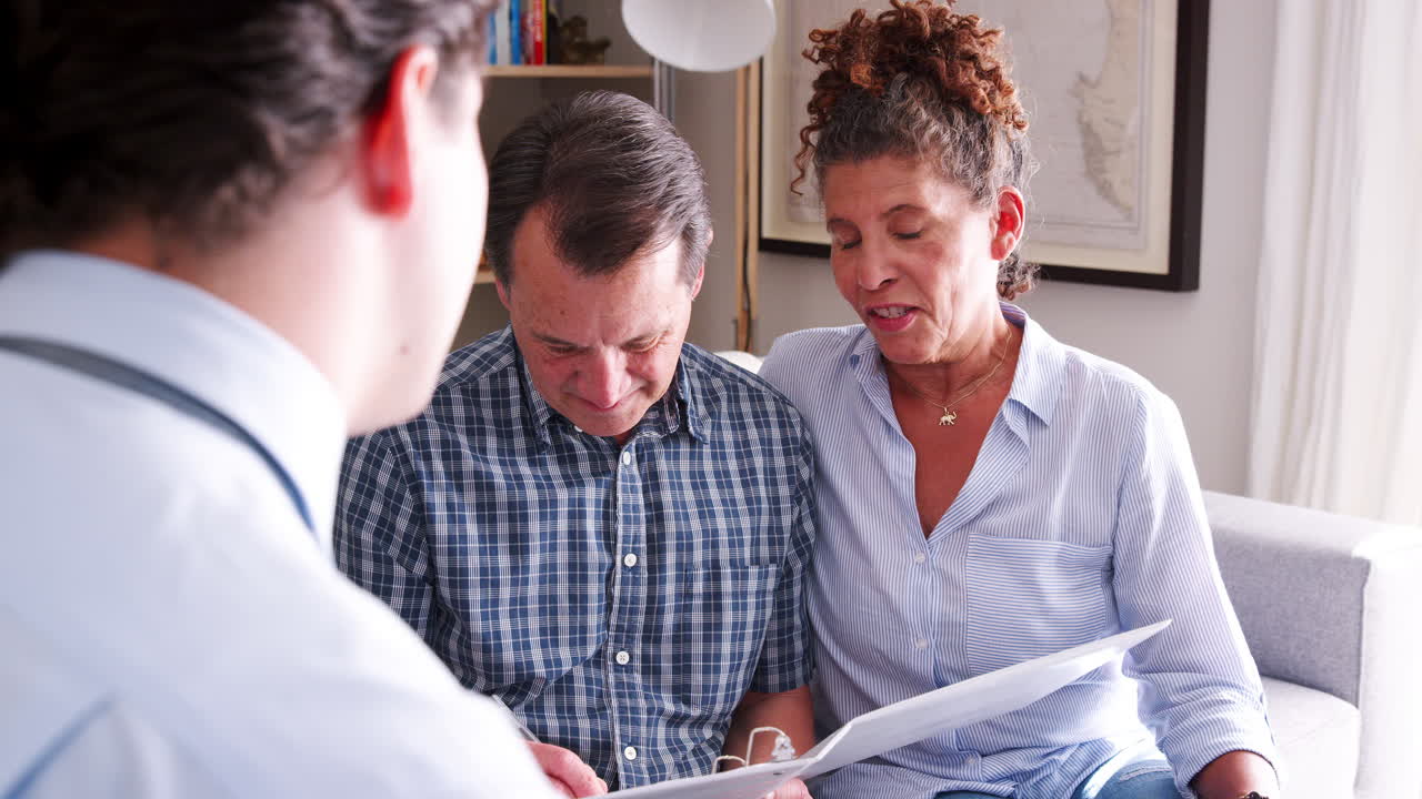 coppia anziana si incontra con un consulente finanziario maschio e firma un documento a casa