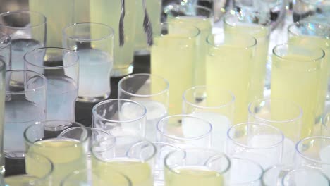 close up of an bartender dropping ice with tongs into glasses, slow motion