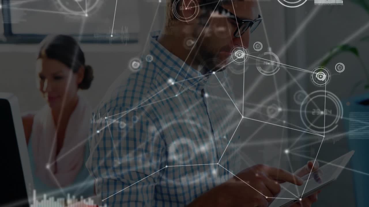 Mid-adult male picking up tablet in office, tapping to expand data network for business insights