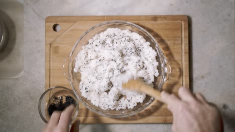 top down time lapse of kitchen counter with a glass bowl of sushi rice being mixed with chai seeds