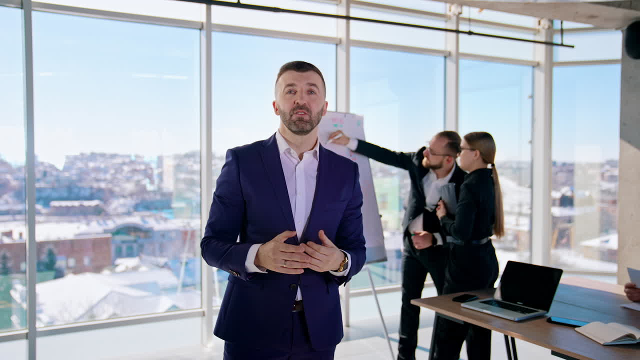 Successful entrepreneur man speaking. Professional businessman in suit talking on camera in office center. Business people work in office in the city.