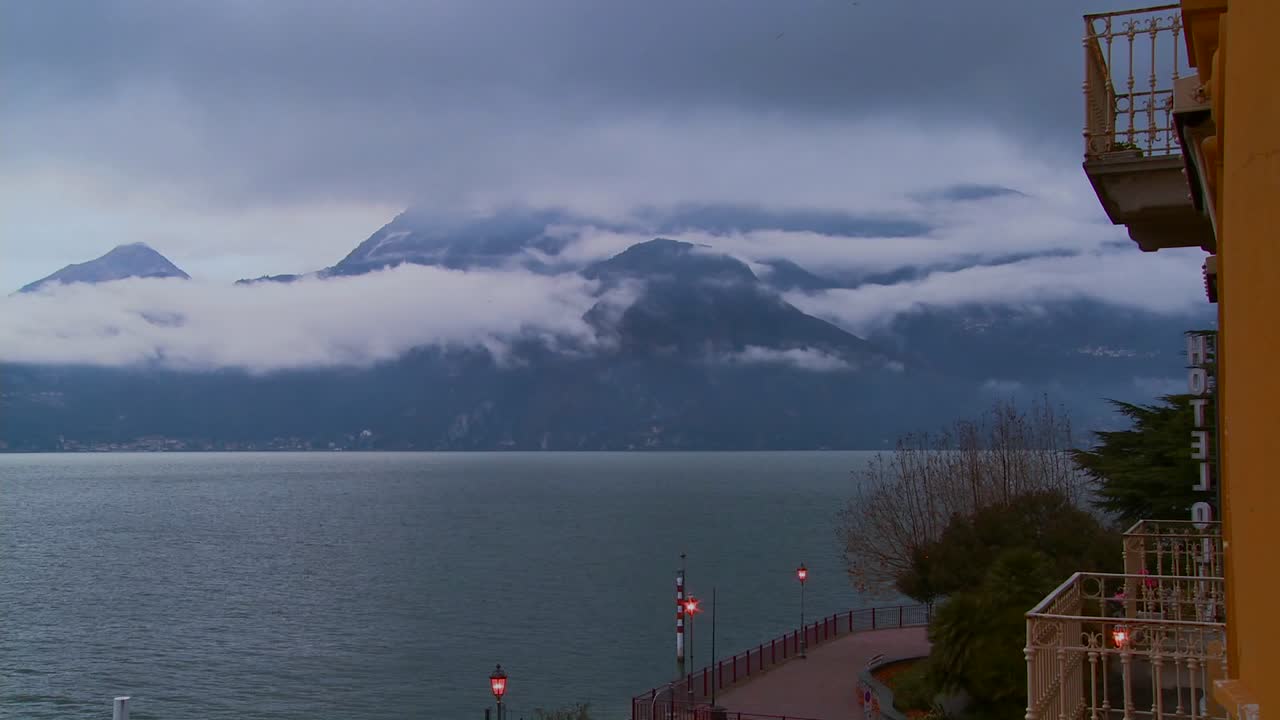 lapso de tiempo de niebla rodando sobre montañas con un balcón de hotel en primer plano 1