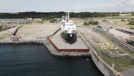 Altes-Boot-Im-Hafen-In-Der-Nähe-Einer-Großen-Brücke-über-Das-Meer