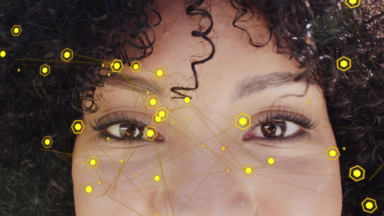 Woman opening eyes and smiling while yellow hex nodes shifting, mapping facial landmarks for tech