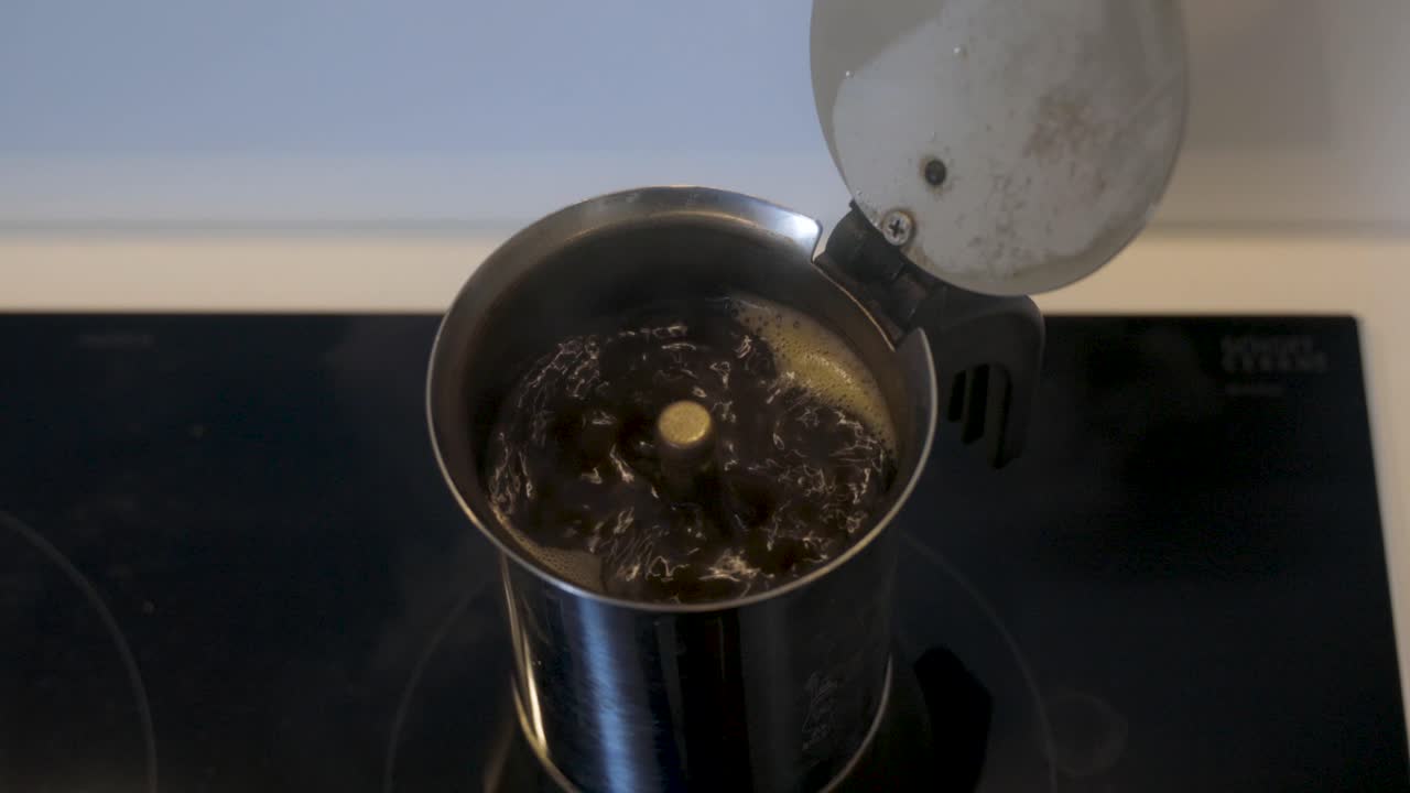 Preparing a fresh cup of coffee in a mocha can