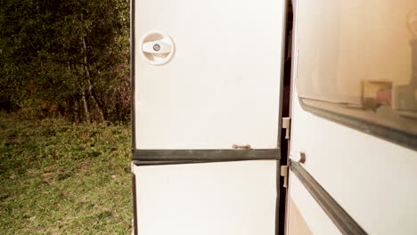 Couple-after-a-walk-in-the-mountain-forest-entering-in-their-retro-camper-van