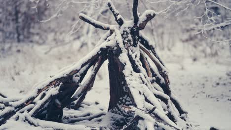 logs arranged in a pyramid covered with the light first snow