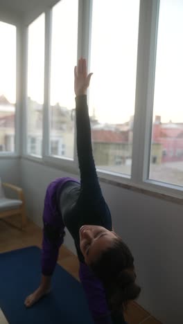 woman practicing yoga on a balcony