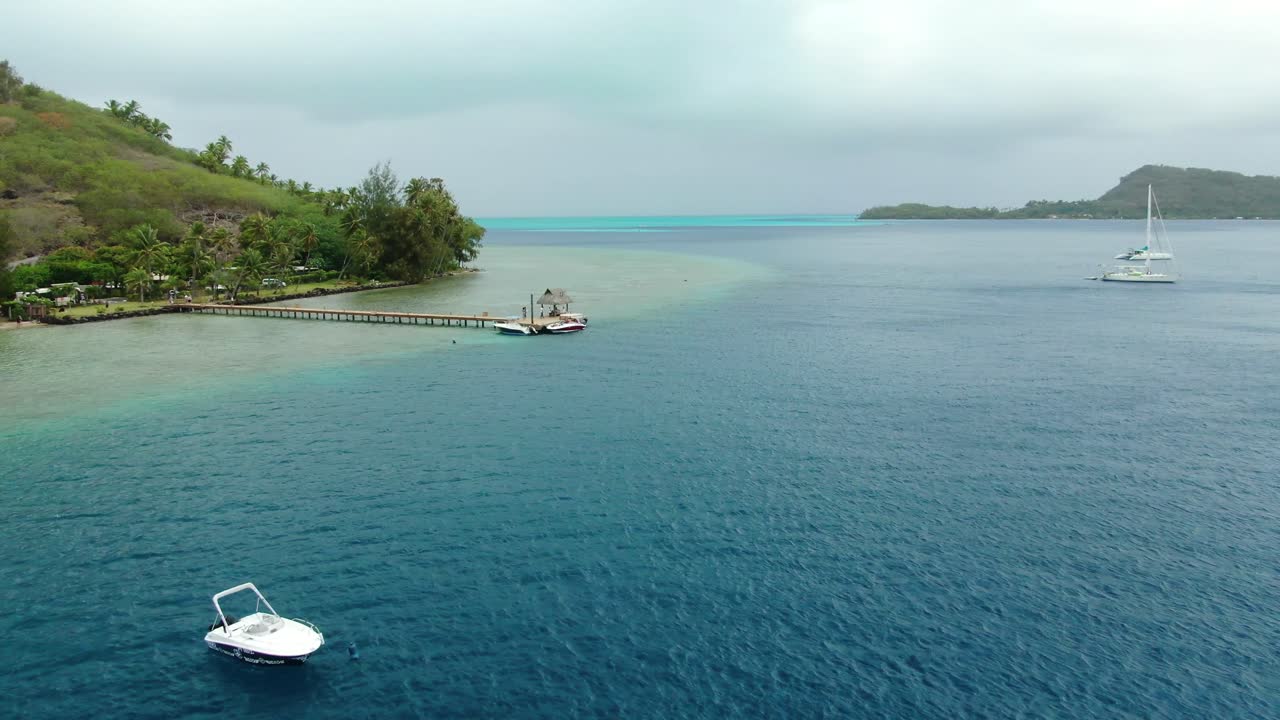 Panning from drone of Bora Bora Lagoon looking out to the reef of blue and turquoise