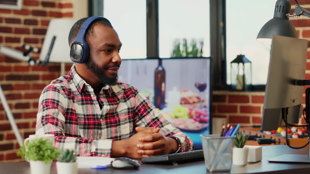 Man in office wearing headphones at desk with computer