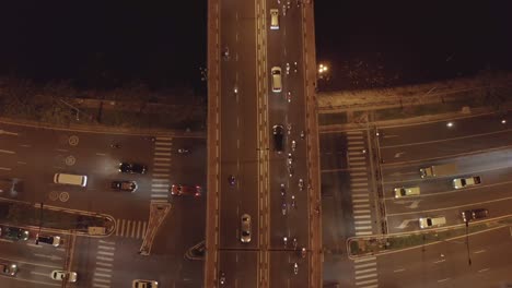 vista de arriba hacia abajo del puente de tráfico ocupado y el paso subterráneo por la noche con rayas de automóviles y motocicletas en movimiento