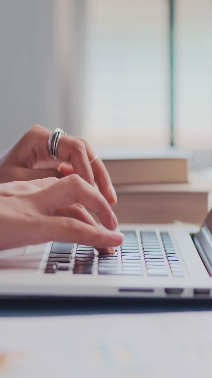 Working on a laptop in a bright indoor space with focused hands