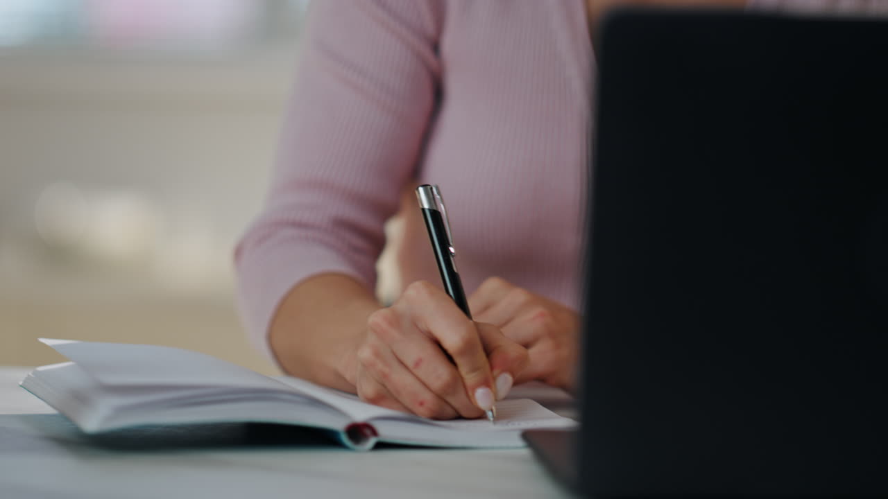 Woman freelancer making notes in notepad sitting home closeup. Girl writing text
