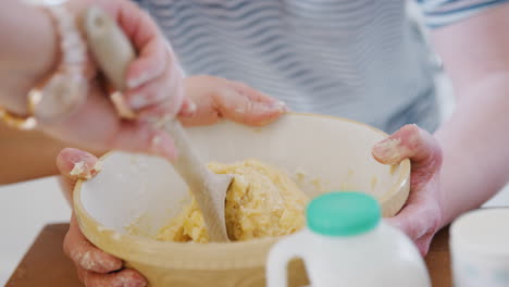 primer plano de una pareja joven con síndrome de down mezclando ingredientes para una receta de pastel en la cocina en casa