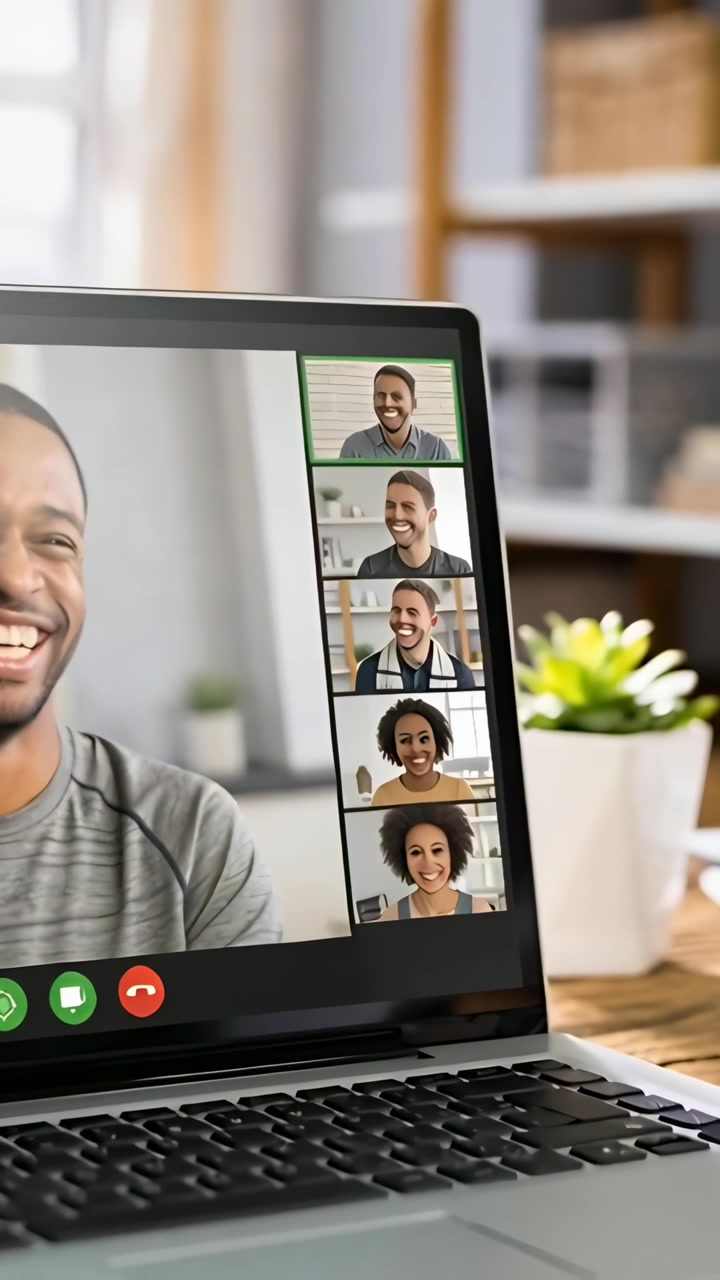 Vertical video: Laptop screen showing laughing man in crewneck leading call at home after accepting