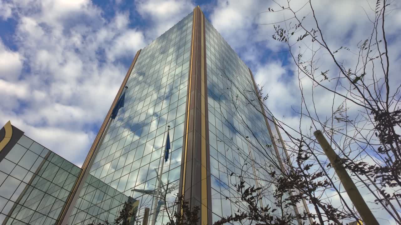 Glass facade of OLAF headquarters building in Brussels under cloudy sky