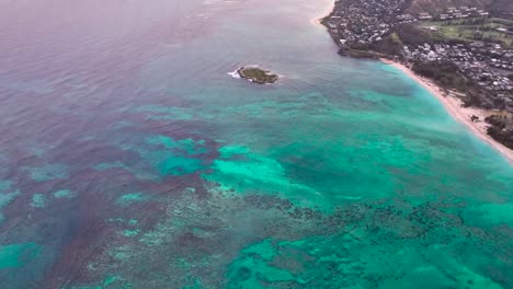 60fps slow mo of lanikai beach panning up to mokulua islands at sunset with bright blue reef at sunset with beautiful color