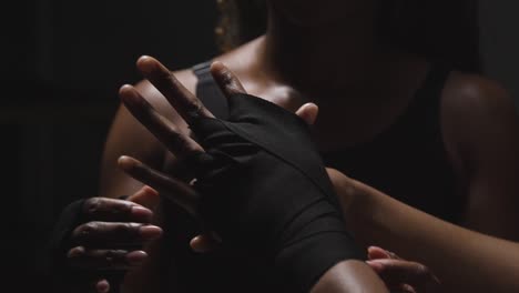 studio shot of women putting on boxing wraps on hands before exercising together 3