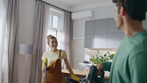 huis schoonmaakpaar lacht close-up. vrouw met vloermoep die met man praat