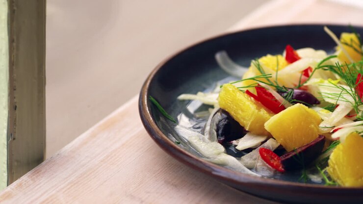 Shaved fennel salad on a table by a window, close up pan