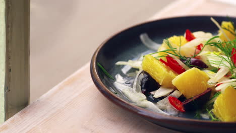 Shaved-fennel-salad-on-a-table-by-a-window,-close-up-pan